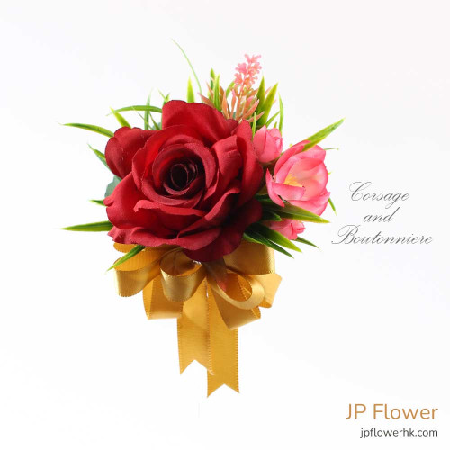 一對精緻的紅玫瑰襟花與手花，展現香港製造的細膩客製化花藝。